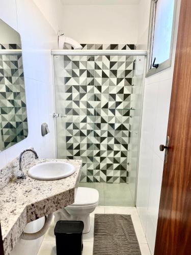 a bathroom with a toilet and a sink and a shower at Hotel JCA Uberlândia in Uberlândia