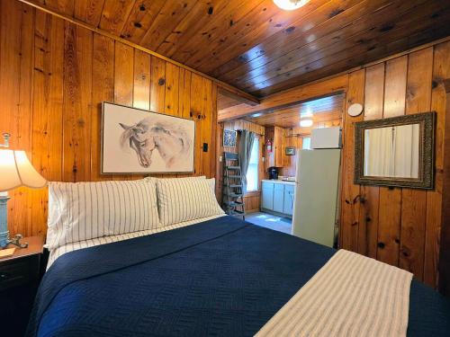 a bedroom with a bed in a room with wooden walls at #08 - One Bedroom Lakeview Cottage-Pet Friendly in Hot Springs