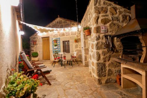 a stone walled patio with a table and chairs at Casa Rural El Berrueco in Robledillo