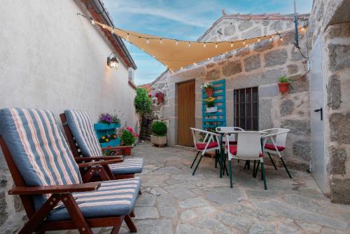 a patio with chairs and a table in an alley at Casa Rural El Berrueco in Robledillo