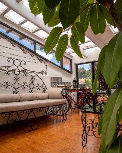 a living room with a bench and some windows at Tika Wasi Casa Boutique in Cusco