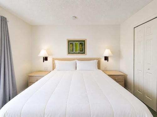 a large white bed in a room with two night stands at See you in Orlando in Kissimmee
