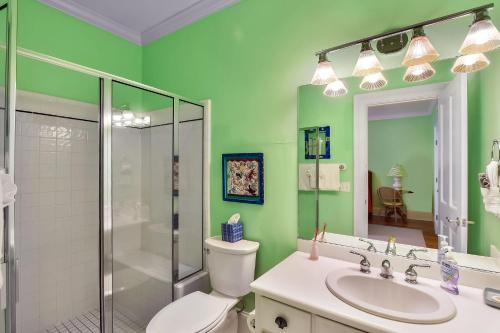 a bathroom with a toilet and a shower and a sink at Avonlea Cottage in Saint Simons Island