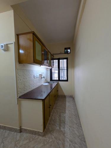 an empty kitchen with a sink and a window at JUST WALKING DISTANCE FROM Temble in Guruvāyūr