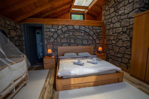 a bedroom with a bed in a stone wall at Modatepe Bungalow & Otel in Uğurlu