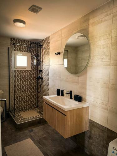 a bathroom with a sink and a shower with a mirror at maison de rivière in Afantou