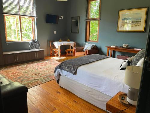 a bedroom with a bed and a table and chairs at RHOOM in Burgersdorp