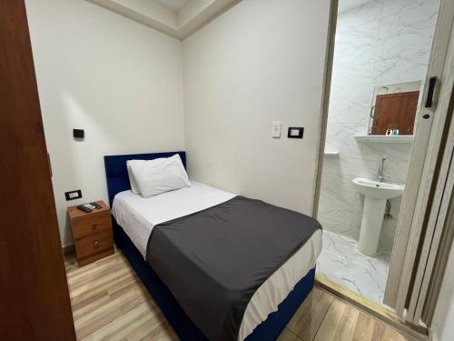 a small bedroom with a bed and a sink at The Rivénto Boutique with Breakfast - Downtown,Cairo in Cairo