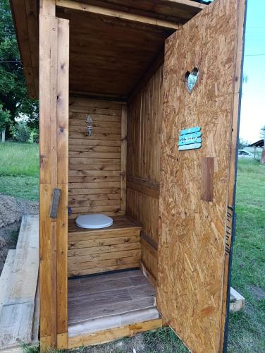a wooden outhouse with a toilet in it at Útulná Maringotka in Dolní Město