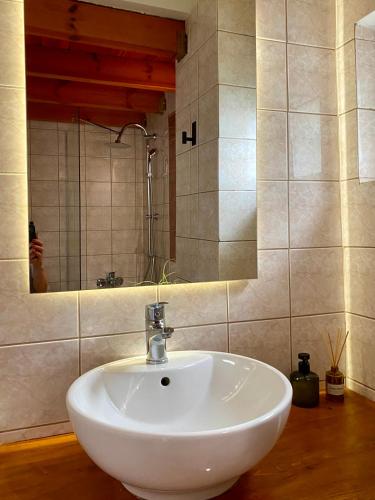 a white sink in a bathroom with a person taking a picture at A&D Houses No3 in Patra