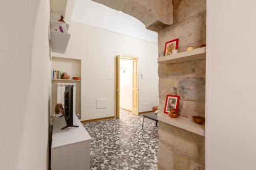 a room with a stone wall and a hallway with a mirror at Rifugio del Sole in Cutrofiano