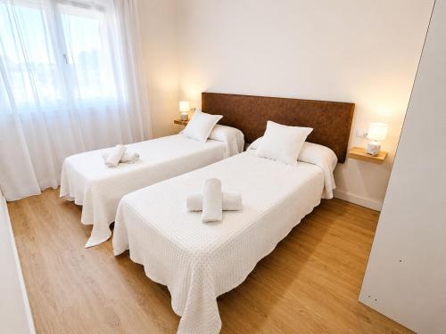 two beds in a room with white sheets at Airtegal A Capelada Cedeira in Cedeira