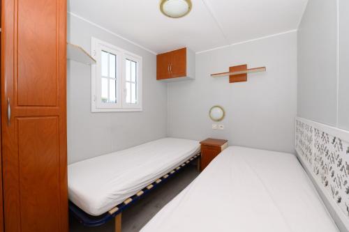 two beds in a small room with a window at La Dune d’Erdeven in Erdeven