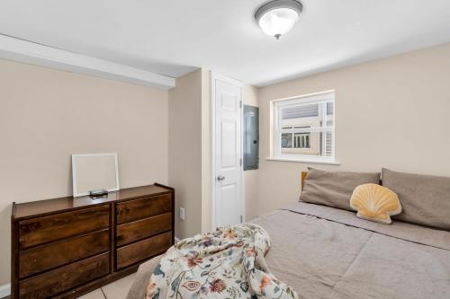 a bedroom with a bed and a dresser and a window at 4BR Bungalow Steps to the Beach in Seaside Heights