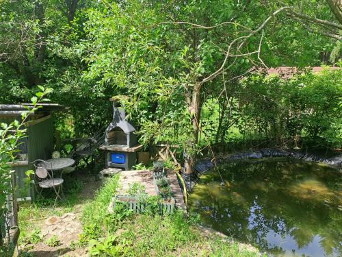 a garden with a pond and a table and a bird house at Das Altsteirische Landhaus - La Maison de Pronegg - Feriendomizil im Biosphärenpark Wienerwald in Pressbaum