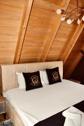 a bed with two black and white pillows on it at Batllava Premium Resort Villa's in Orllan