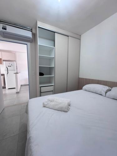 a bedroom with a white bed and a closet at apartamento ana julia modesto in Juazeiro do Norte