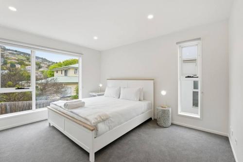 a white bedroom with a bed and a large window at Stylish Rosetta River Escape in Rosetta