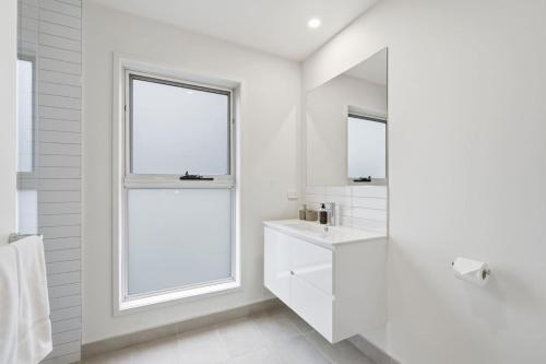 a white bathroom with a sink and a window at Stylish Rosetta River Escape in Rosetta