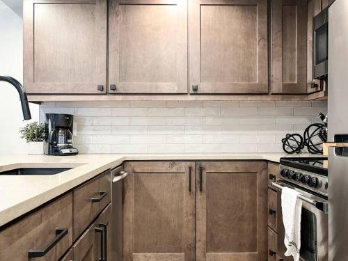 a kitchen with wooden cabinets and a stove top oven at Alpenglow Bungalow in Steamboat Springs