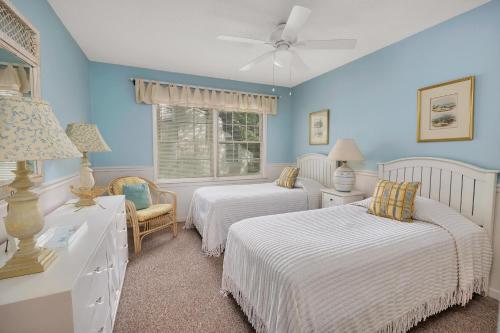 two beds in a room with blue walls at Oceanwood 109 in Saint Simons Island