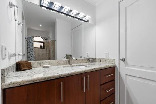 a bathroom with a sink and a large mirror at Oceanview Condo Across From Beach with Resort Pool in Tamarindo