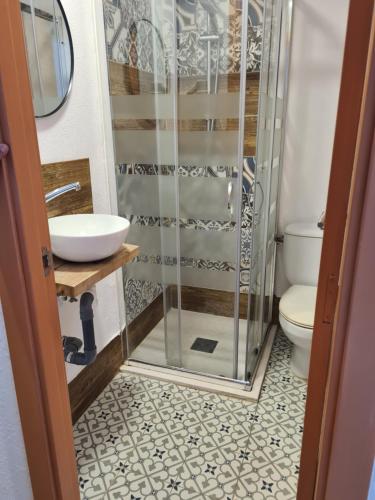 a bathroom with a shower and a sink and a toilet at Hostal Blanc Lloret in Lloret de Mar