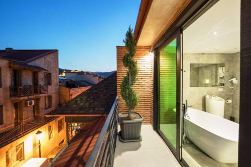 a bathroom with a tub and a toilet and a sink at Mit Hotel Tbilisi in Tbilisi City