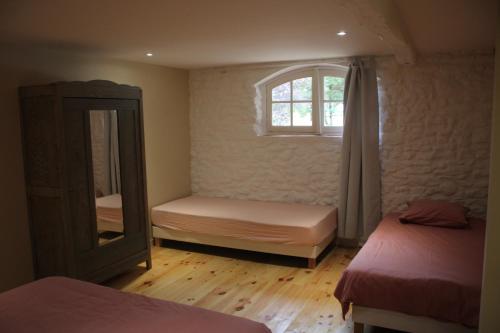 a bedroom with two beds and a mirror and a window at Domaine de Calabel in Pouylebon