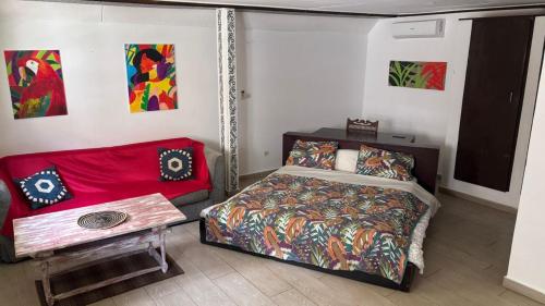 a small bedroom with a bed and a couch at Chambres d'hôtes WAIMEA in Abidjan