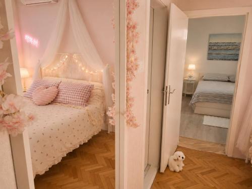 a bedroom with a white bed with a canopy at Nina in Baška Voda