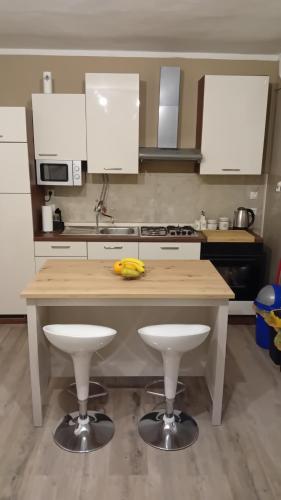 a kitchen with a wooden counter with two stools at Apartments Bulovic Bozo Ap1 in Podglavica