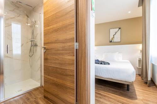 a bathroom with a shower and a bed in a room at Hotel La Terraza in Miño