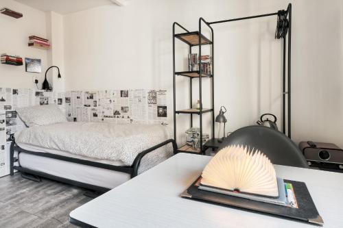 a bedroom with a bed and a table with a book at Be my Guest House in Wijk aan Zee