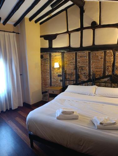 a bedroom with a large bed with two towels on it at Posada de Candelario in Candelario