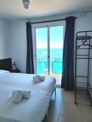 a bedroom with a bed with a view of the ocean at Hostal Blanc Lloret in Lloret de Mar