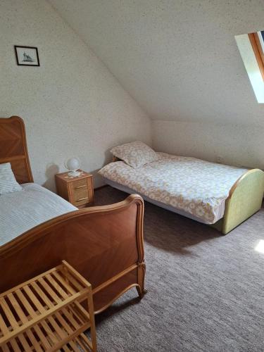 two twin beds in a room with two tables at Chatka Mysliwego Wladka in Wola Piotrowa