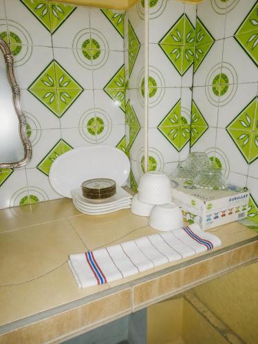 a counter with a table with plates and a lamp at Marchica House in Nador