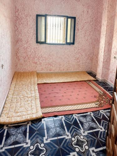 a small room with a bed and a window at Marchica House in Nador