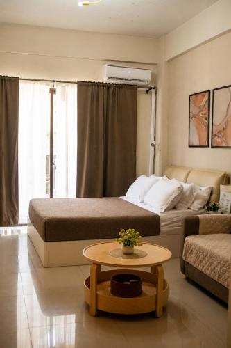a hotel room with two beds and a coffee table at Crosswinds Tagaytay Holiday Home by KTCH in Tagaytay