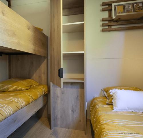 a bedroom with two bunk beds and a closet at Camping Le Boem in Balazuc