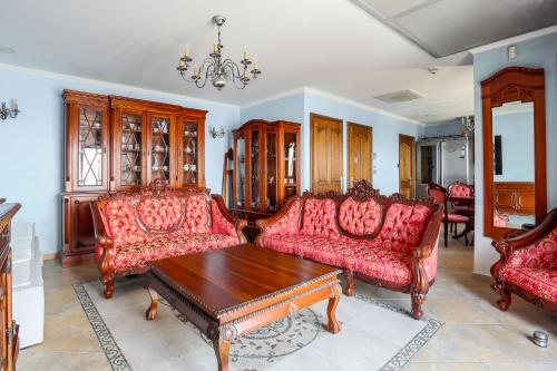 a living room with red couches and a table at La Coraillère Waterfront Villa with Private Pool and Sea Access in Théoule-sur-Mer