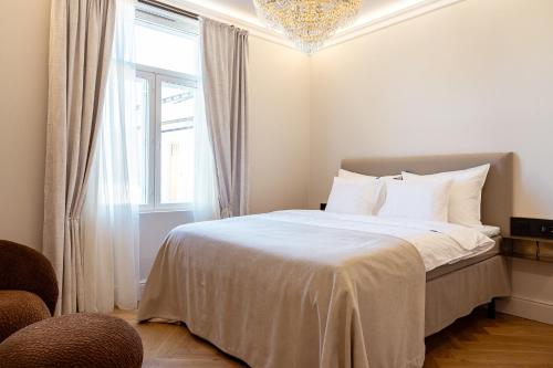 a bedroom with a bed with a chandelier and a window at Sugar Factory Apartments in Kotka