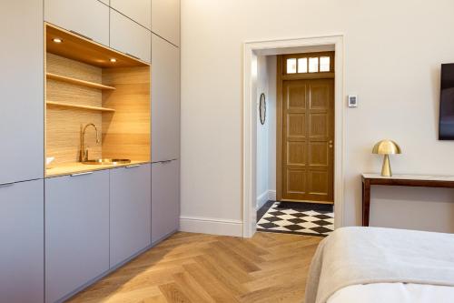 a room with a bed and a sink and a door at Sugar Factory Apartments in Kotka