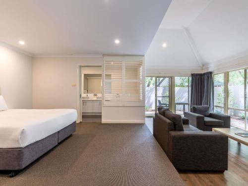 a bedroom with a bed and a couch and a desk at Bayview Geographe Resort in Busselton