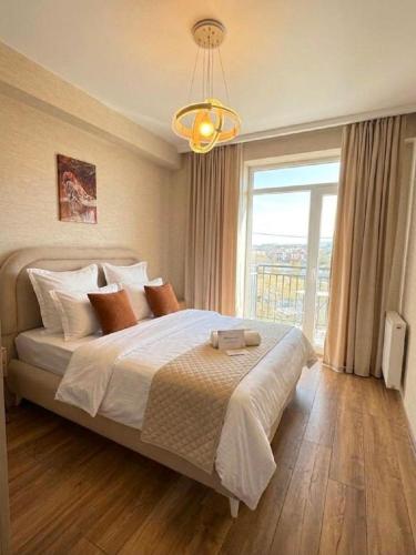 a bedroom with a large bed with a large window at My Sweet Apartment in Tbilisi City