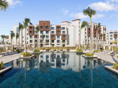 an image of a resort pool with buildings in the background at Rixos Murjana - Ultra All Inclusive in King Abdullah Economic City