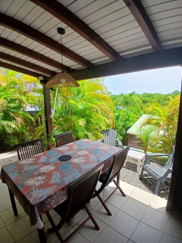 a table and chairs on a patio with a view at Ti Village Creole in Sainte-Anne