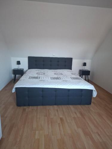 a bedroom with a large blue bed with two end tables at Ferienhaus Petig in Pritzerbe