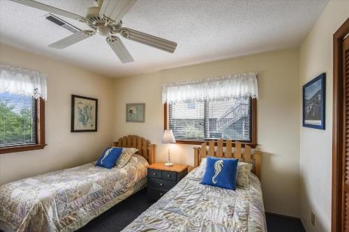 a bedroom with two beds and a ceiling fan at Hurricane Charlie's in Duck